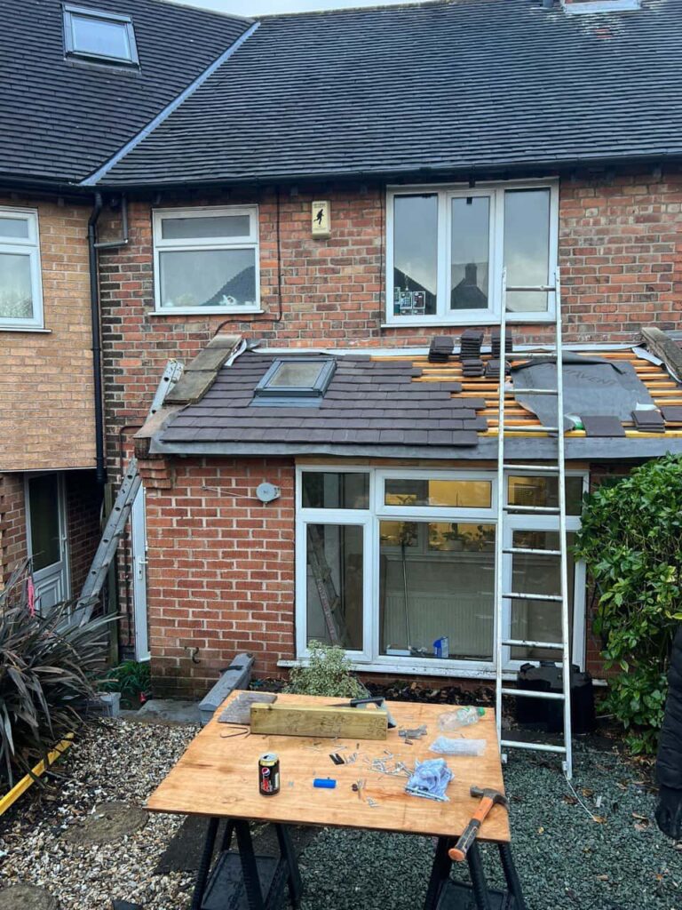 This is a photo of a roof extension that is having new roof tiles installed. This is a photo taken from the roof ridge looking down a tiled pitched roof on to a flat roof. Works carried out by Beeston Roofing Repairs