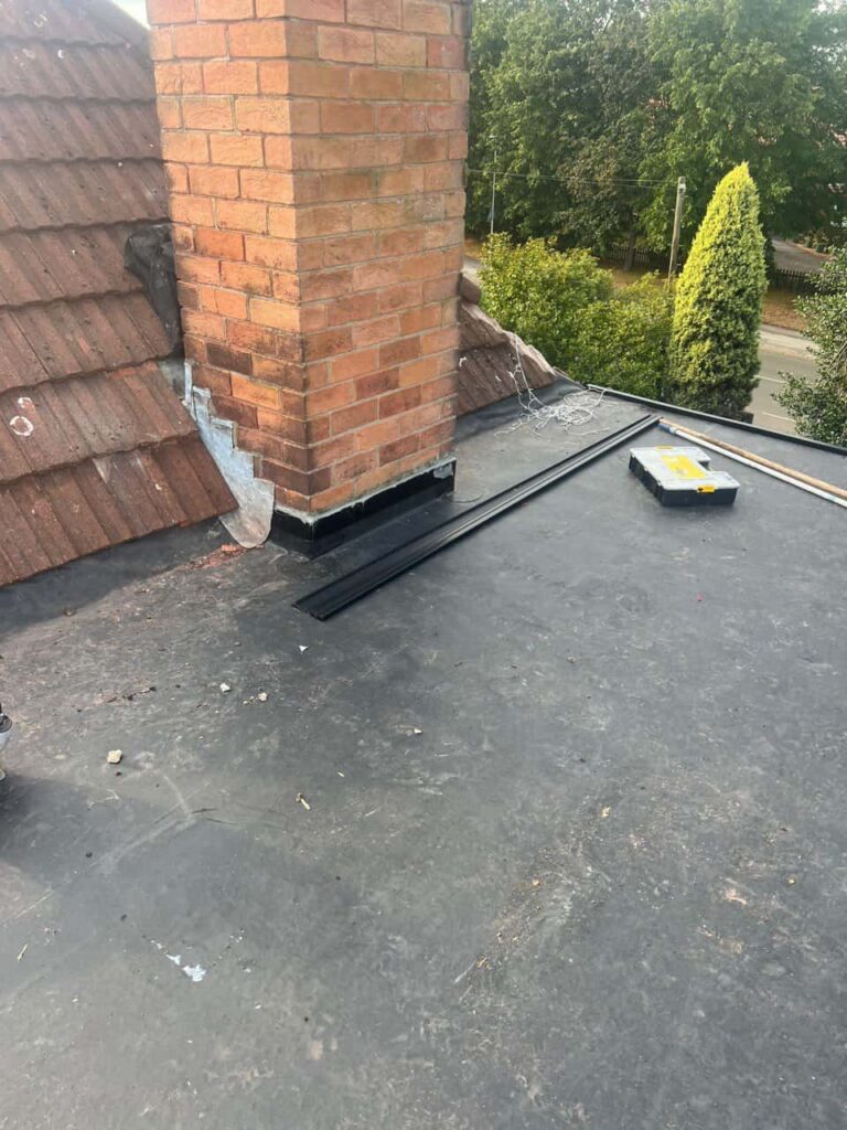 This is a photo of a flat roof which has just been repaired, there is also a chimney stack and some leadwork has also been dressed. Works carried out by Beeston Roofing Repairs